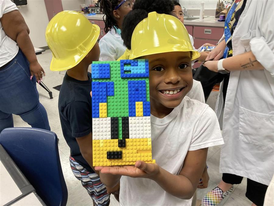 Student showing off lego